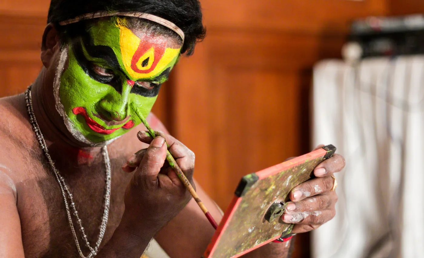 Kathakali makeup being applied by hand